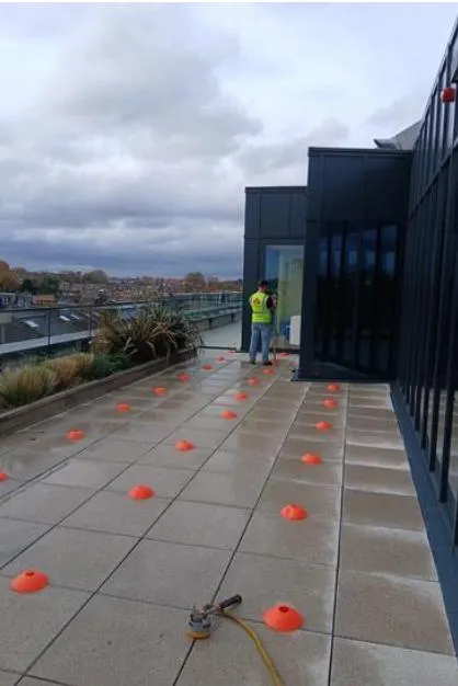 Electrical field survey in progress on the Parklife roof terrace, with survey markers set out across the paving